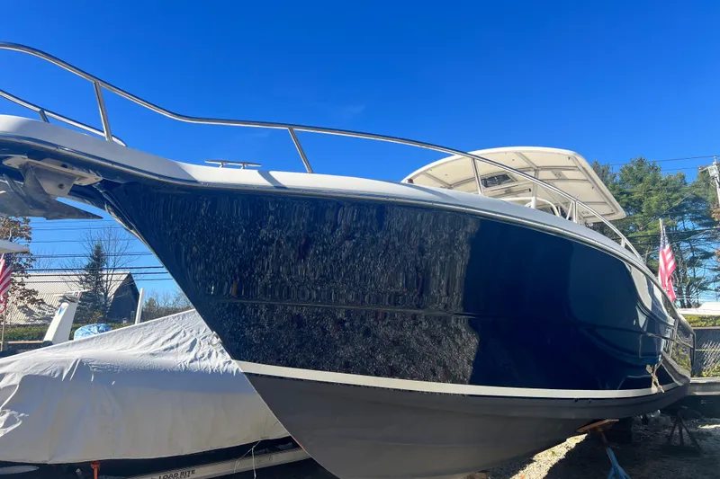 Slide: The Image of 2001 Pursuit 3070 Center Console boat with sleek design under clear blue sky. - 49