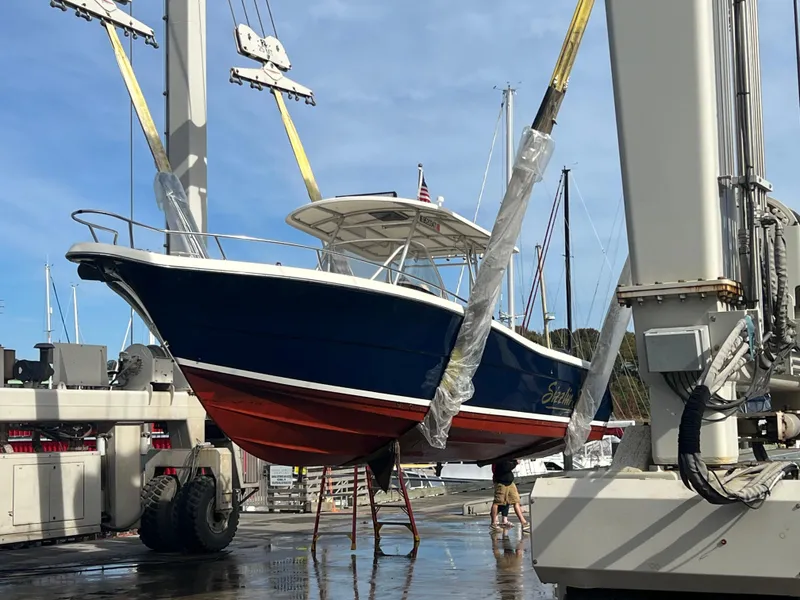 Slide: The Image of 2001 Pursuit 3070 Center Console boat being lifted at a marina. - 5