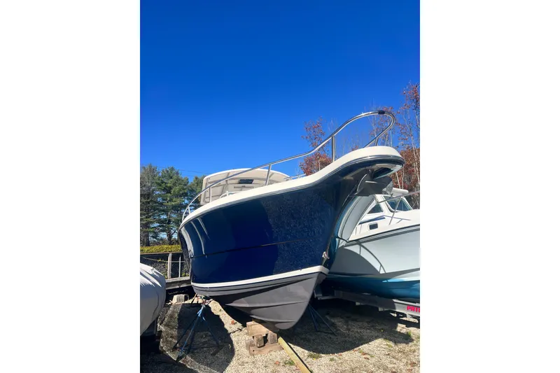 Slide: The Image of 2001 Pursuit 3070 Center Console boat on dry dock under clear blue sky. - 50