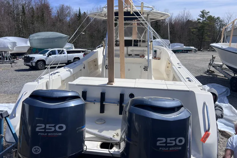 Slide: The Image of 2001 Pursuit 3070 Center Console boat with twin 250 four-stroke engines in a storage yard. - 53