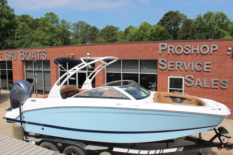 The Image of 2025 Four Winns HD3 OB boat displayed at a dealership with service and sales signage. - 1