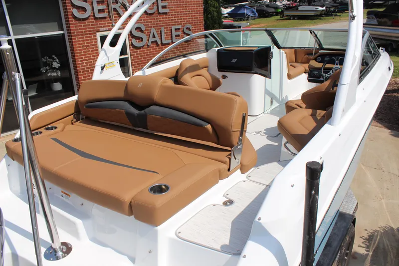 Slide: The Image of 2025 Four Winns HD3 OB boat with tan seating, showcased at a sales service location. - 10