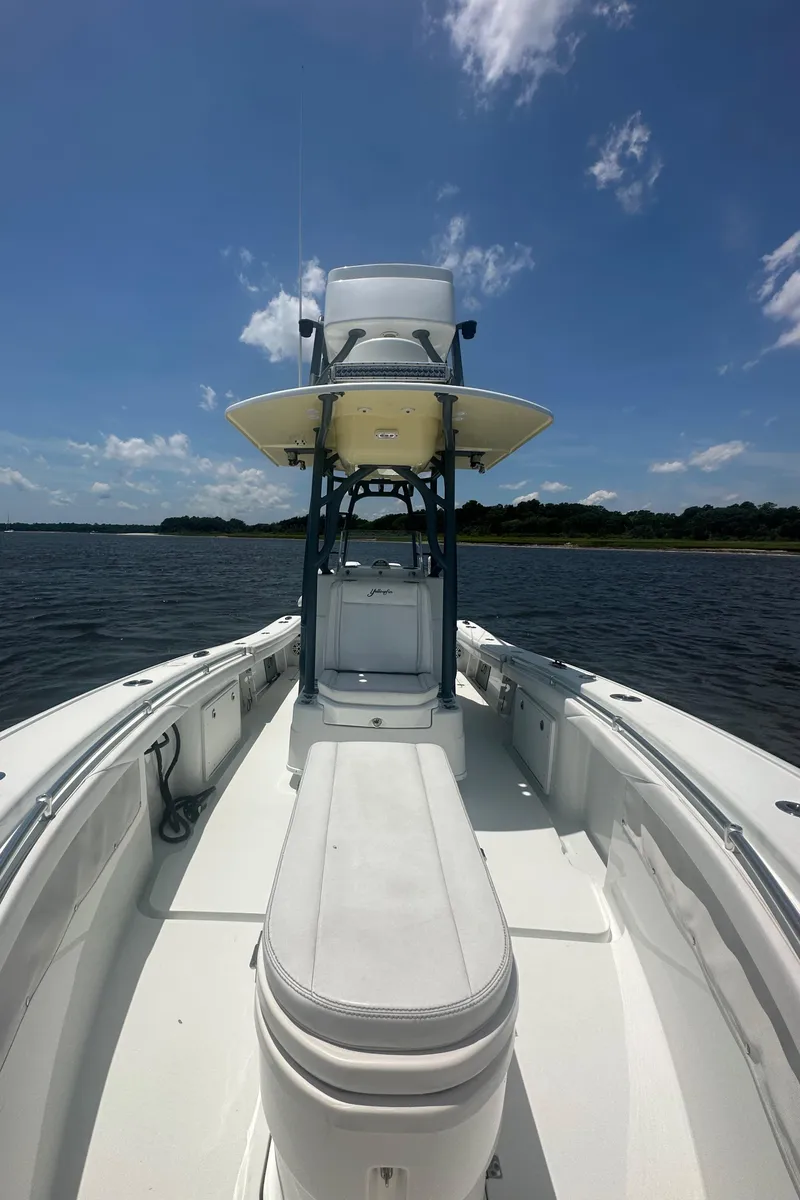 Slide: The Image of 2020 Yellowfin 26 Hybrid boat on water under clear blue sky. - 12