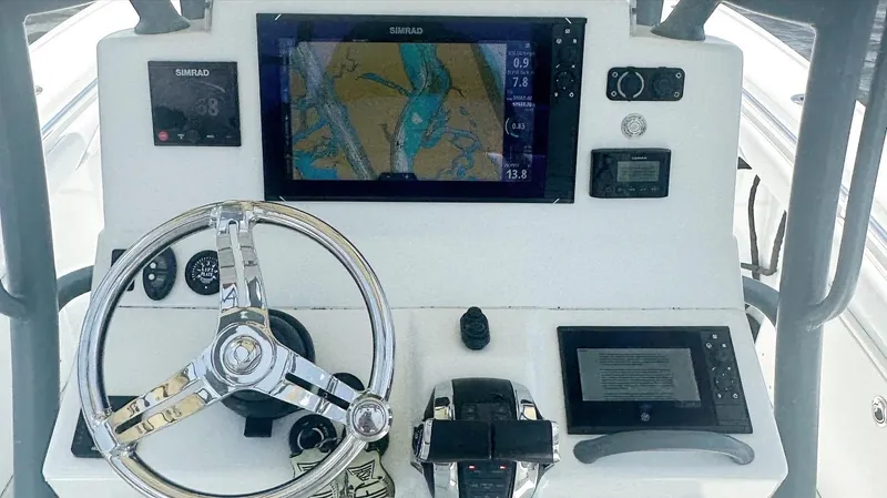 Slide: The Image of Control panel of a 2020 Yellowfin 26 Hybrid boat with navigation screens and steering wheel. - 7