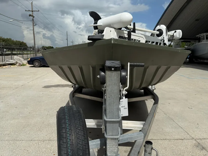 Slide: The Image of 2015 Alweld 1870 boat on trailer, parked outdoors under cloudy sky. - 2