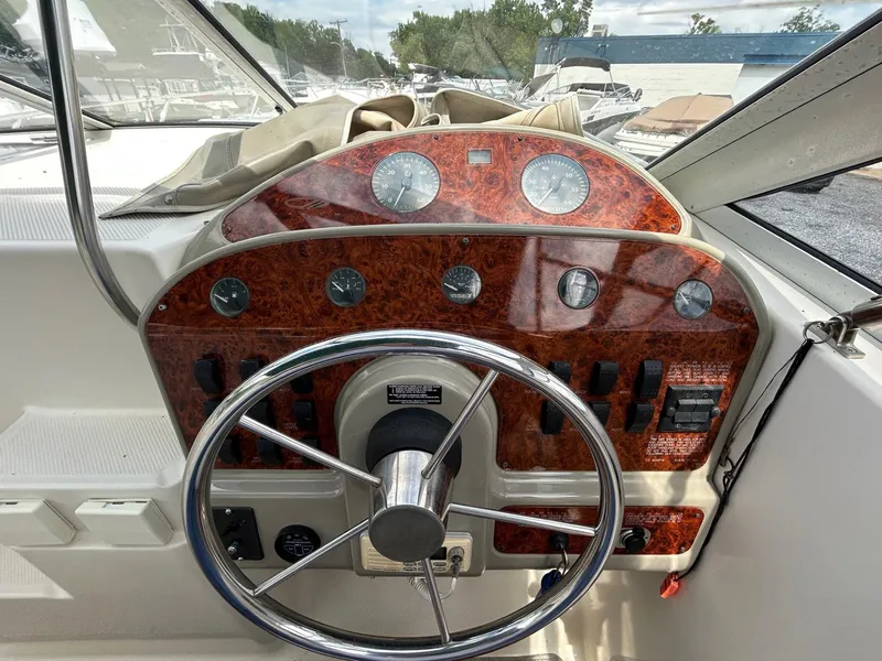 Slide: The Image of 1998 Maxum 2800 SCR boat dashboard with wood paneling and steering wheel. - 13