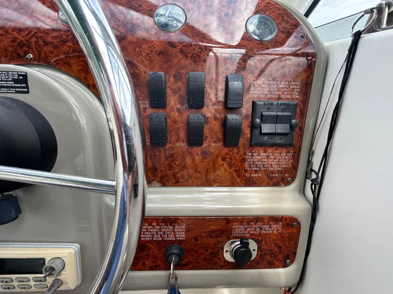 Slide: The Image of 1998 Maxum 2800 SCR boat dashboard with wood paneling and control switches. - 15