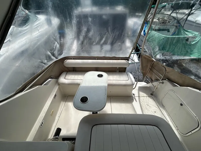 Slide: The Image of 1998 Maxum 2800 SCR boat interior with seating and table, featuring clear protective covers. - 17