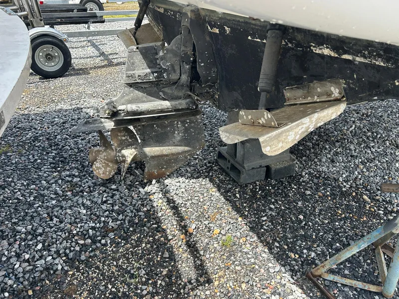 Slide: The Image of 1998 Maxum 2800 SCR boat propeller and stern drive on gravel. - 22