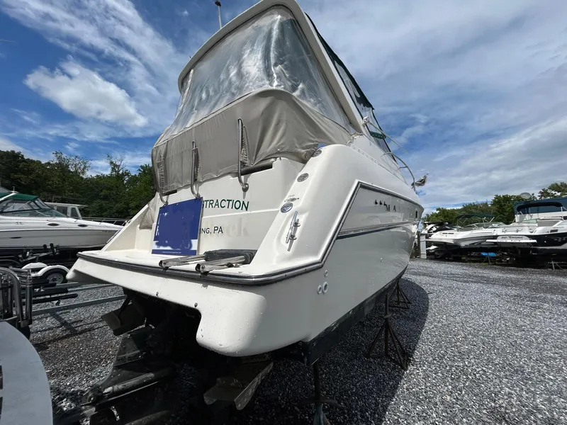 Slide: The Image of 1998 Maxum 2800 SCR boat on gravel lot under cloudy sky. - 24