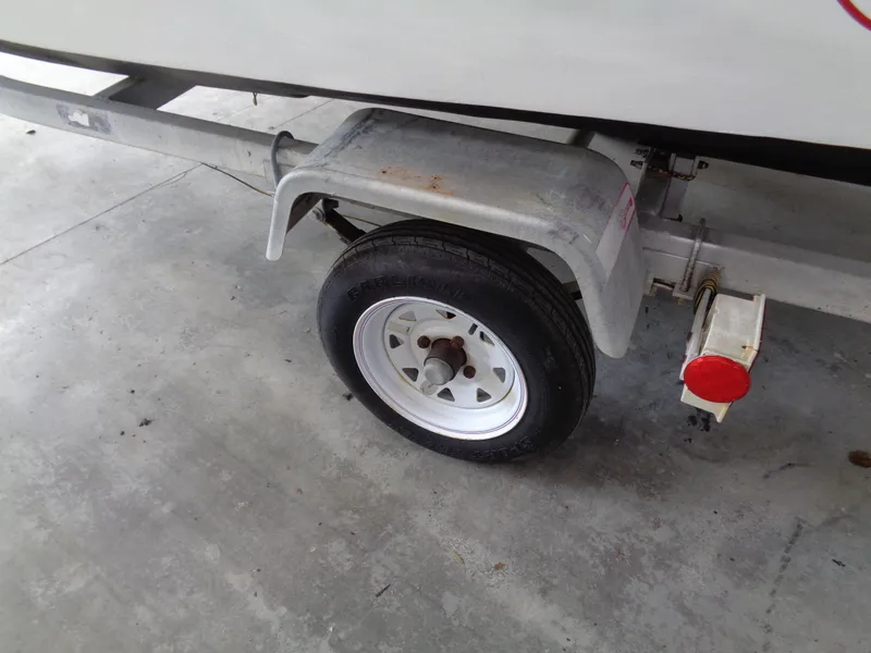 Slide: The Image of Trailer wheel of a 1964 Boston Whaler 13 Sport boat on concrete floor. - 13