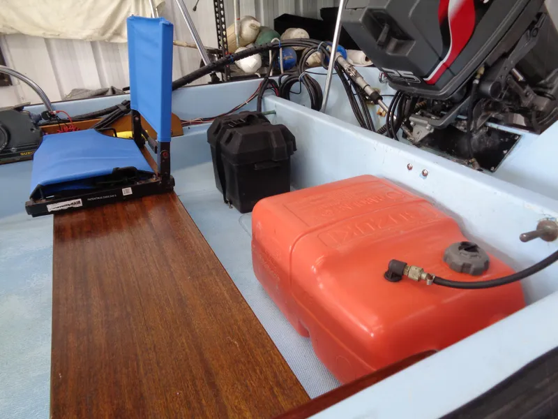 Slide: The Image of 1964 Boston Whaler 13 Sport interior with blue seat, fuel tank, and engine components. - 14