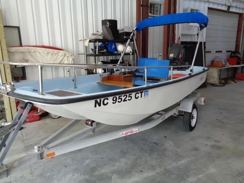 Slide: The Image of 1964 Boston Whaler 13 Sport boat on trailer in a garage setting. - 2