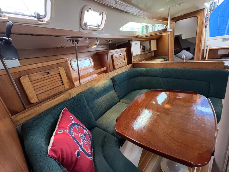 Slide: The Image of Cozy interior of 1998 Catalina 34 MkII sailboat with wooden table and green seating. - 14