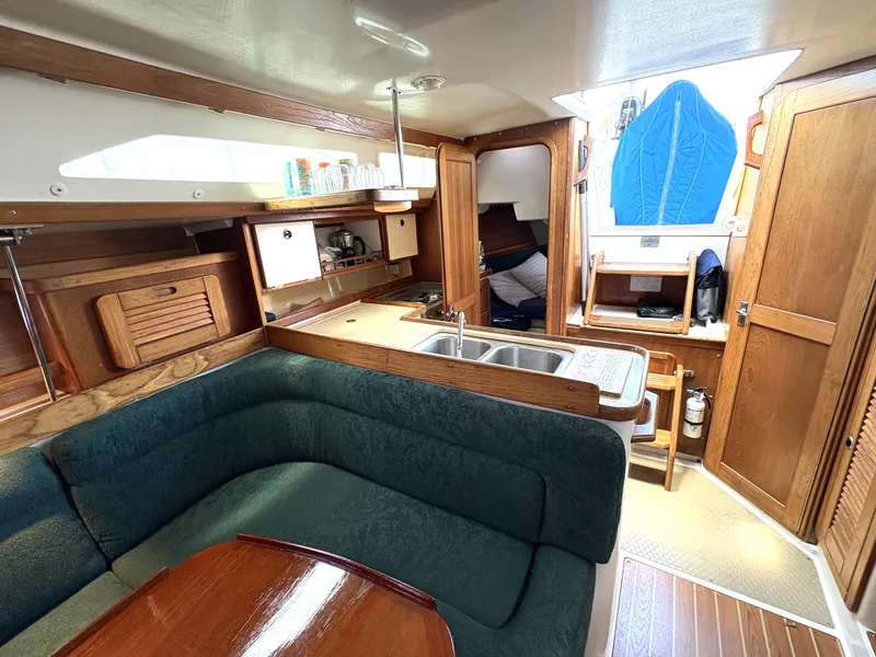 Slide: The Image of Interior of 1998 Catalina 34 MkII sailboat with cozy seating and compact kitchen area. - 15