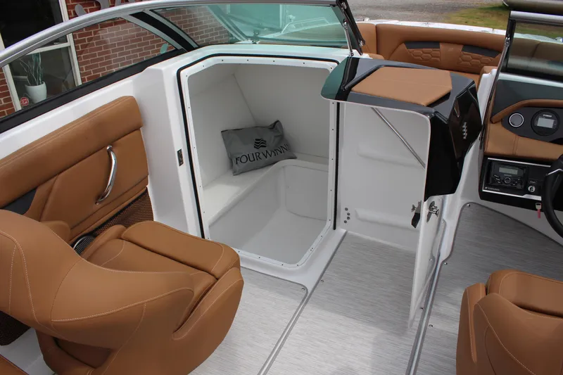 Slide: The Image of 2025 Four Winns HD3 OB boat interior with tan seating and storage compartment. - 16