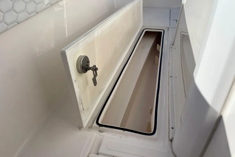 Slide: The Image of Storage compartment on a 2021 Stamas 31 Adventura boat, featuring a secure lock mechanism. - 16