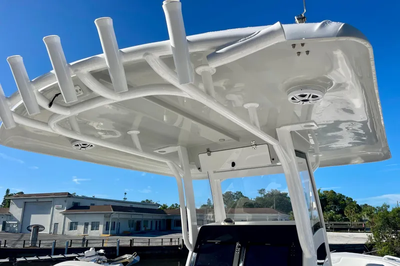 Slide: The Image of 2021 Stamas 31 Adventura boat with T-top and rod holders, docked under clear blue sky. - 21