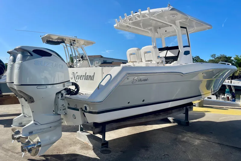 Slide: The Image of 2021 Stamas 31 Adventura boat with Suzuki engines, docked under clear blue sky. - 3