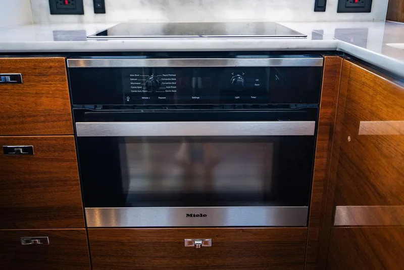 Slide: The Image of Modern kitchen with Miele oven, wood cabinetry, and sleek design on a Princess S62 yacht. - 48