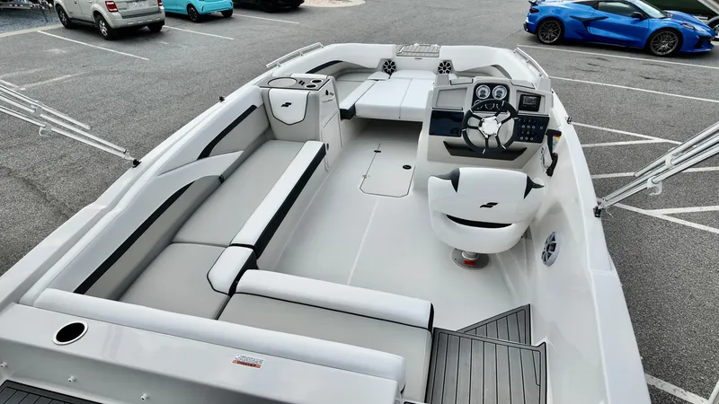Slide: The Image of 2026 Starcraft SVX 211 OB boat interior with seating, steering console, and modern design in a parking lot. - 16