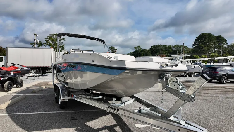 Slide: The Image of 2026 Starcraft SVX 211 OB boat on trailer in parking lot, under cloudy sky. - 3