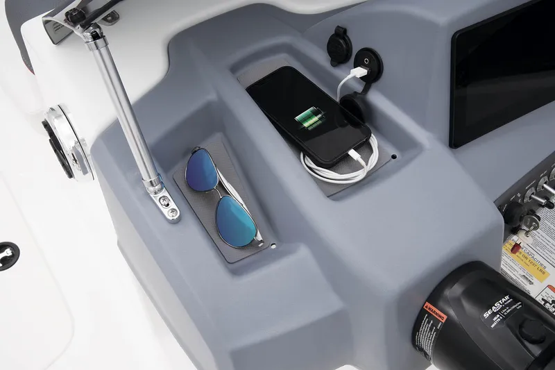 Slide: The Image of 2023 Tahoe T18 boat console with phone charging, sunglasses, and control panel. - 40