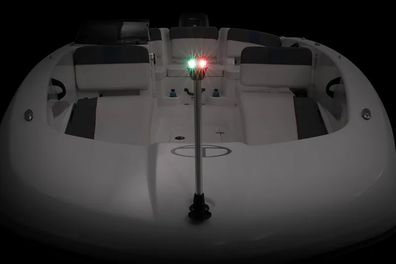 Slide: The Image of 2023 Tahoe T18 boat with navigation lights, viewed from the front in low light. - 56
