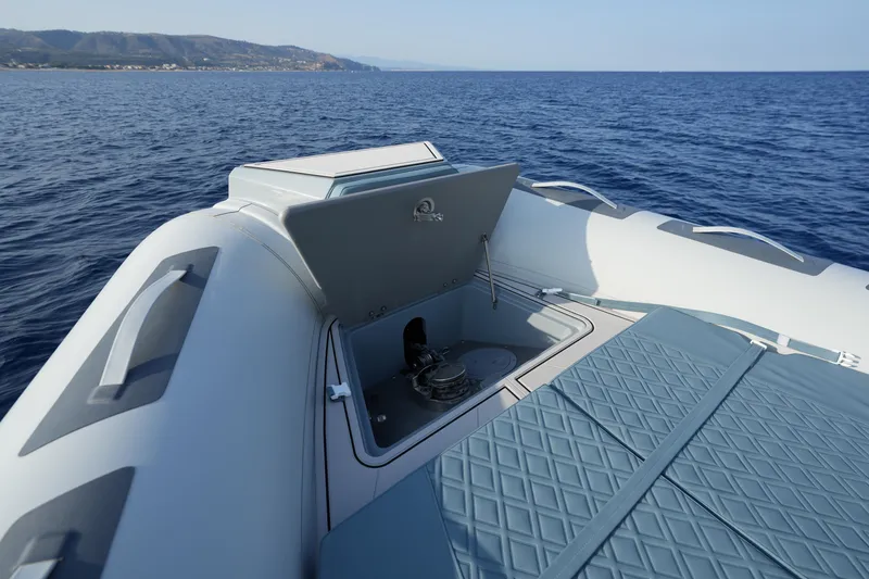 Slide: The Image of 2026 Ranieri Cayman 33 Executive boat with open storage compartment on calm sea. - 11