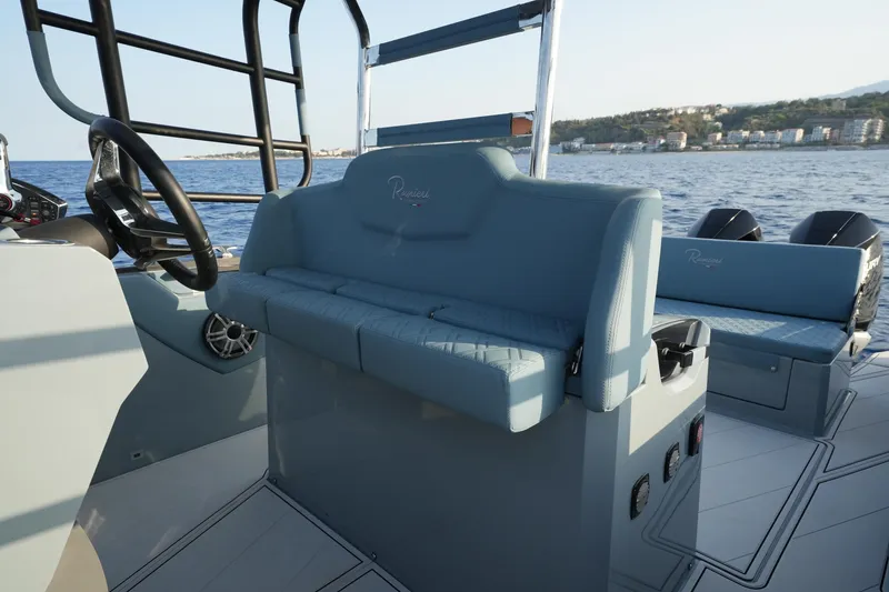 Slide: The Image of 2026 Ranieri Cayman 33 Executive boat interior with seating and steering wheel, on open water. - 13