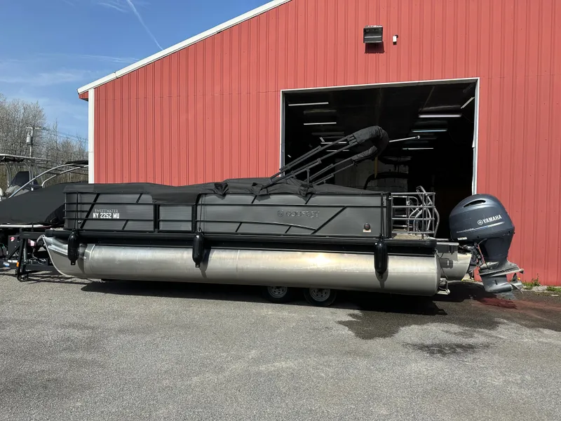 Slide: The Image of 2023 Godfrey SWEETWATER 2286 SFL pontoon boat with Yamaha engine, parked outside red building. - 13