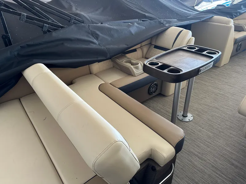 Slide: The Image of 2023 Godfrey SWEETWATER 2286 SFL boat interior with beige seating and table. - 15