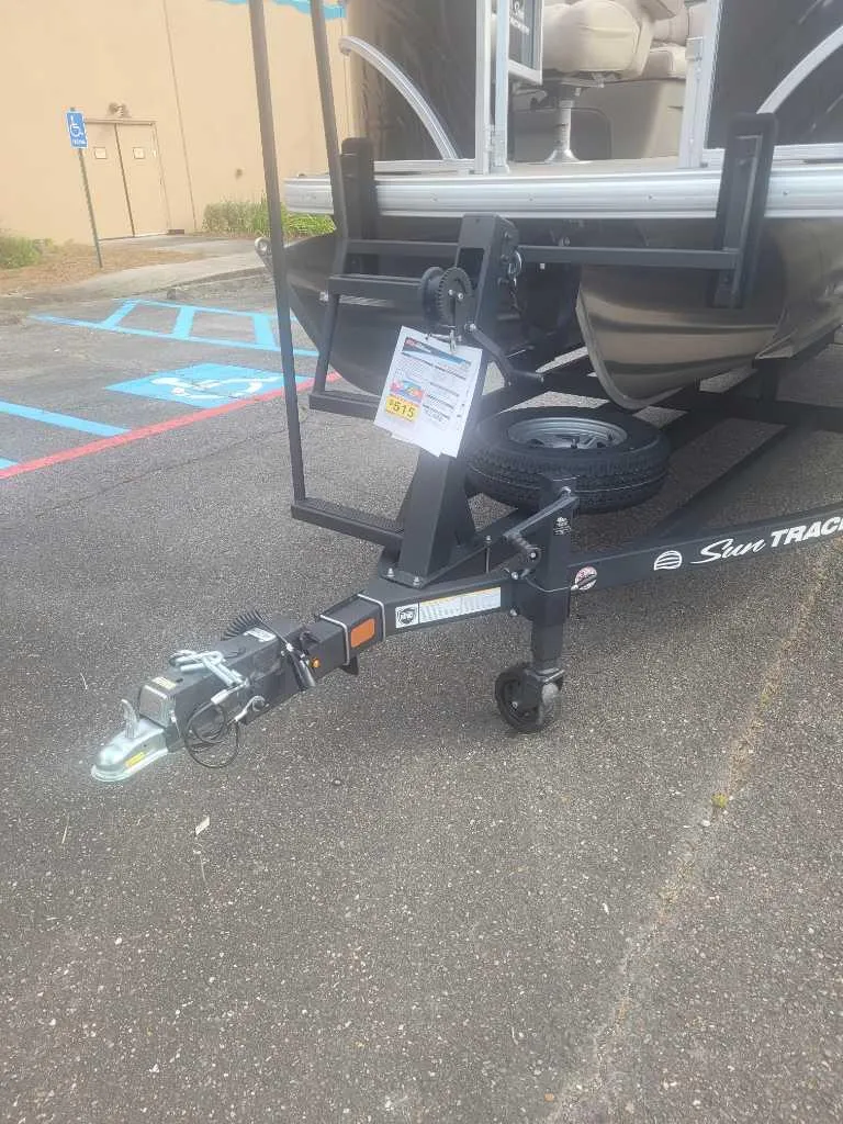 Slide: The Image of 2025 Sun Tracker Sportfish 24 XP3 boat trailer in parking lot, close-up view. - 11