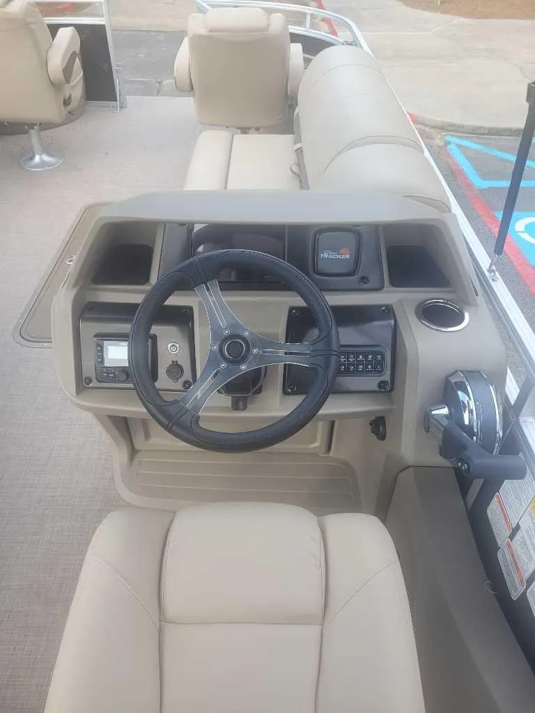 Slide: The Image of 2025 Sun Tracker Sportfish 24 XP3 boat dashboard with steering wheel and controls. - 4