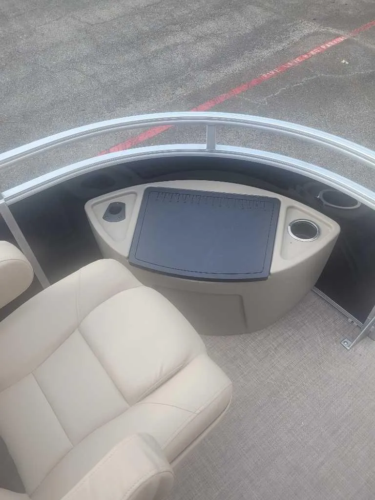 Slide: The Image of 2025 Sun Tracker Sportfish 24 XP3 boat interior with beige seating and console. - 6