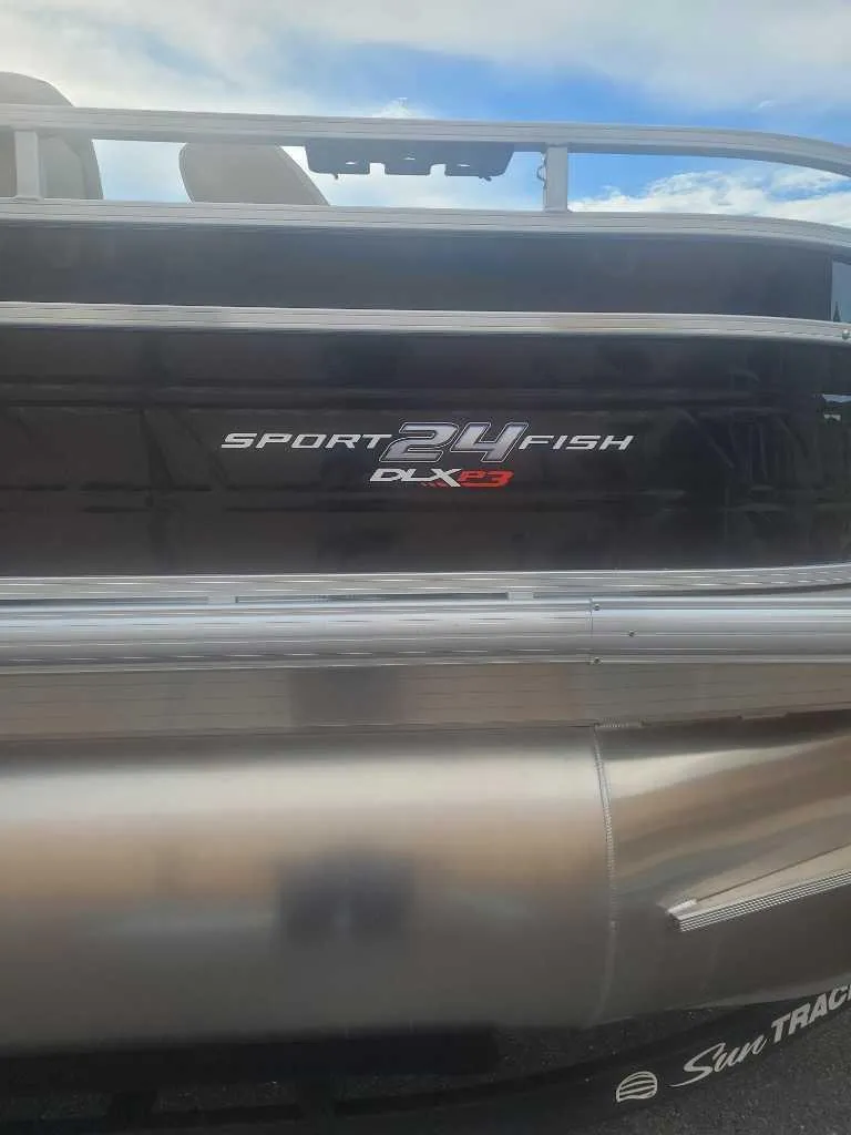 Slide: The Image of 2025 Sun Tracker Sportfish 24 XP3 boat, rear view with logo and railing. - 9