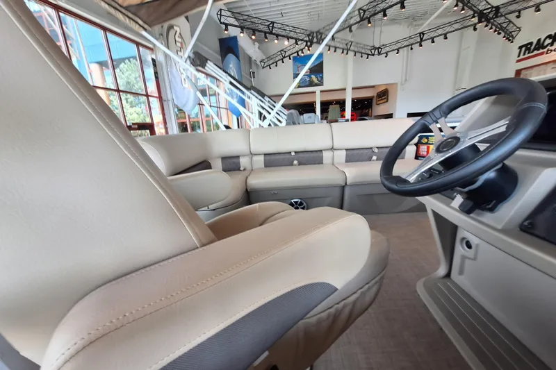 Slide: The Image of Interior view of 2025 Sun Tracker Sportfish 24 XP3 boat with beige seating and steering wheel. - 8