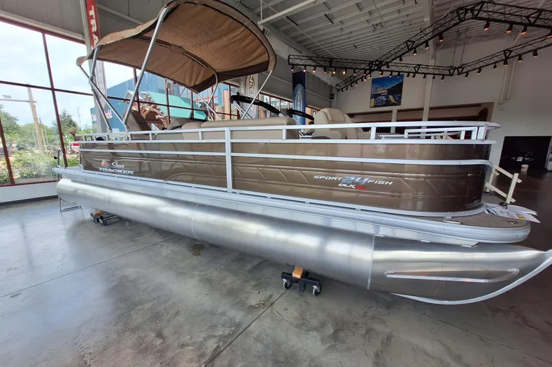 The Image of 2025 Sun Tracker Sportfish 24 XP3 pontoon boat displayed indoors, featuring sleek design and spacious seating. - 0