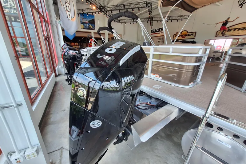 Slide: The Image of 2025 Sun Tracker Sportfish 24 XP3 pontoon boat with powerful outboard motor in showroom. - 7