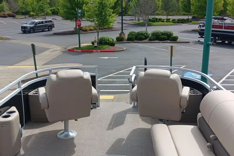 Slide: The Image of 2025 Sun Tracker Sportfish 24 XP3 boat interior with beige seating in a parking lot. - 5
