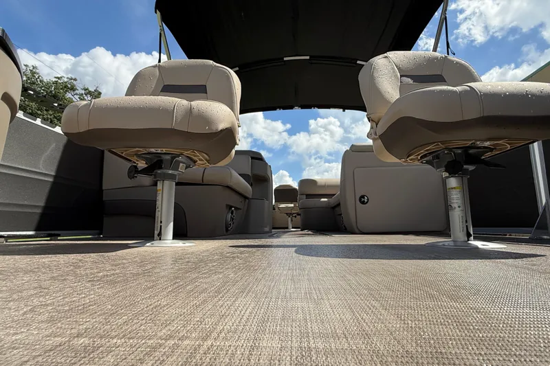 Slide: The Image of 2025 Sun Tracker Fishin' Barge 22 XP3 interior with seating and canopy under blue sky. - 73
