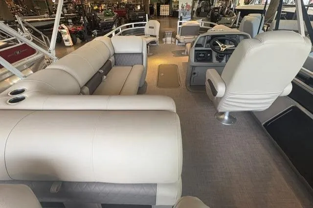 Slide: The Image of 2025 Sun Tracker Fishin' Barge 22 XP3 interior with plush seating and steering console. - 4