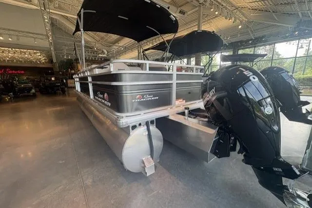 Slide: The Image of 2025 Sun Tracker Fishin' Barge 22 XP3 pontoon boat with dual Mercury engines in showroom. - 6
