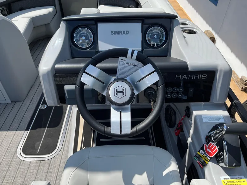Slide: The Image of 2026 Harris Solstice 230 boat dashboard with steering wheel and Simrad display. - 10