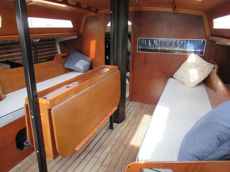 Slide: The Image of Interior of a 1984 Santa Cruz 50 sailboat with wooden furnishings and cozy seating. - 13