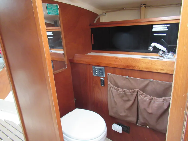 Slide: The Image of 1984 Santa Cruz 50 yacht bathroom with wooden cabinetry, sink, and toilet. - 16