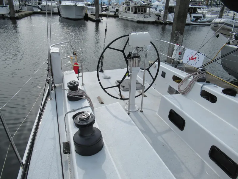 Slide: The Image of 1984 Santa Cruz 50 sailboat cockpit with steering wheel, docked at marina. - 4