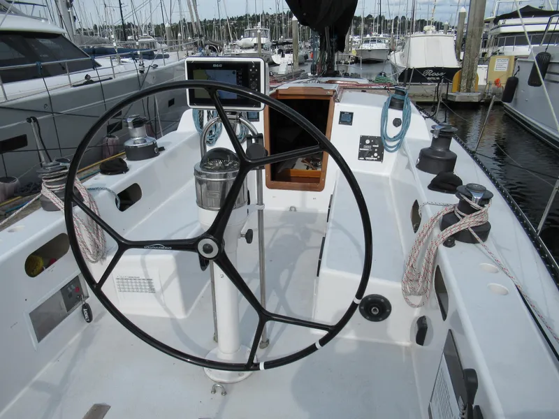 Slide: The Image of Cockpit of a 1984 Santa Cruz 50 sailboat with steering wheel and marina view. - 5