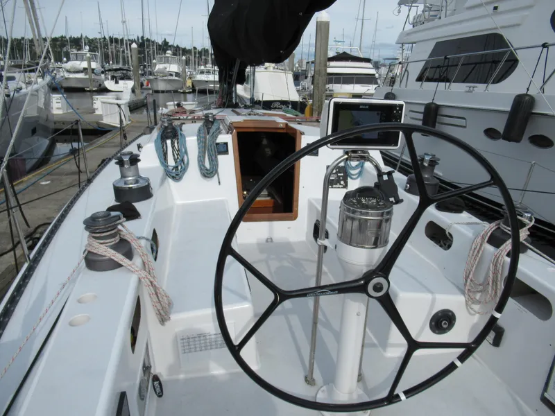 Slide: The Image of Cockpit of 1984 Santa Cruz 50 sailboat with steering wheel and ropes, docked at marina. - 6