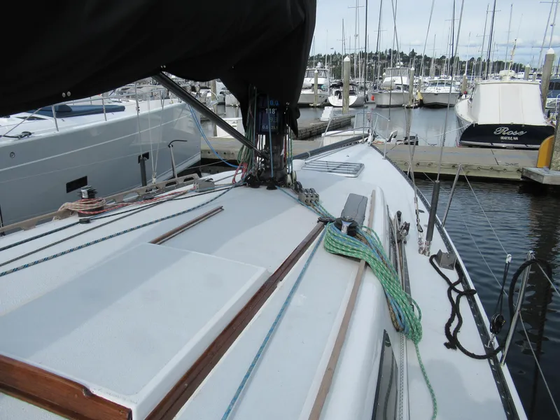 Slide: The Image of 1984 Santa Cruz 50 sailboat deck at marina, featuring rigging and moored boats. - 9